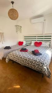 a bedroom with two beds with red pillows on them at Refúgio dos Mauzinhos in Ourondo