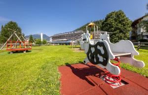 a park with a playground with a swing at Hotel Grimmingblick GesmbH in Bad Mitterndorf