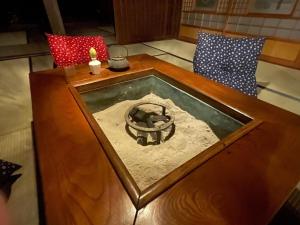 a wooden table with a fireplace in the middle of a room at 陽月 Yo-Getsu in Yamaga +15 photos