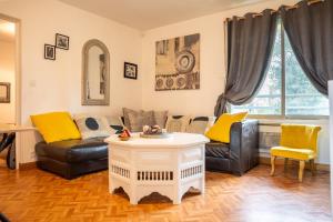 a living room with two couches and a table at Grand appartement 5 pers avec parking proche du centre ville de Toulouse in Toulouse