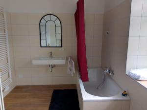 a bathroom with a tub and a sink and a mirror at Railway cottage in Dürnstein in Dürnstein