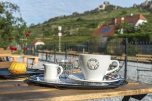 a wooden table with two coffee cups on a tray at Railway cottage in Dürnstein in Dürnstein