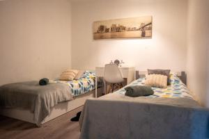 a room with two beds and a chair at Grand appartement 5 pers avec parking proche du centre ville de Toulouse in Toulouse