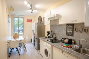 a kitchen with a sink and a table with chairs at Grand appartement 5 pers avec parking proche du centre ville de Toulouse in Toulouse