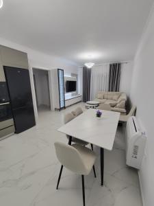 a living room with a white table and chairs at Lux apartment in Kamëz
