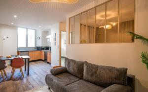 a living room with a couch and a table at Le Vitrail - Climatisation, Parking & Wifi à 150m de la Cathédrale in Rodez