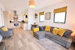 a living room with a couch and a kitchen at Margate Penthouse Private Balconies Sea Glimpses Gated Parking Air-Con The Penthouse Margate in Margate