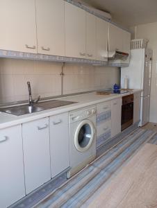 a kitchen with a sink and a washing machine at Salvora in Bueu