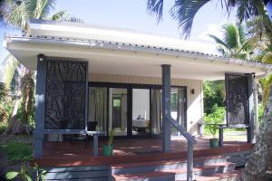 a guest house with a deck and a patio at Purotu Villas in Avarua