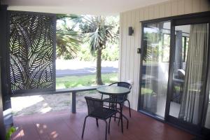 a screened in porch with a table and two chairs at Purotu Villas in Avarua