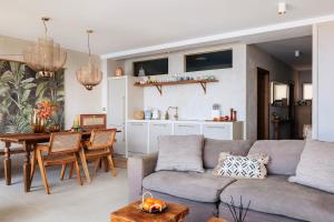 a living room with a couch and a table and a kitchen at I Boho Sun Oceanfront Apartment in Icod de los Vinos