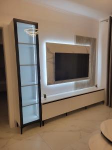 a living room with a flat screen tv on a wall at Lux apartment in Kamëz
