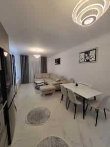 a living room with a couch and a table at Lux apartment in Kamëz