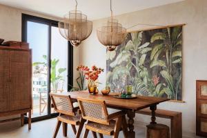 a dining room with a table and chairs and a painting at I Boho Sun Oceanfront Apartment in Icod de los Vinos