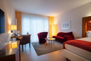 a hotel room with a bed and a table and chairs at Aqua Aurelia Suitenhotel an den Thermen in Baden-Baden