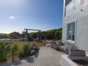 a building with a bench and a view of the ocean at Agulhas Splendour in Agulhas