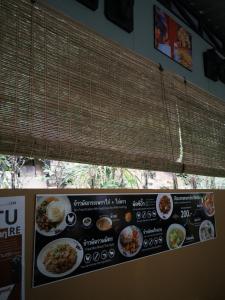 a menu for a restaurant with food on a wall at Laydaman Art Homestay in Ao Luk