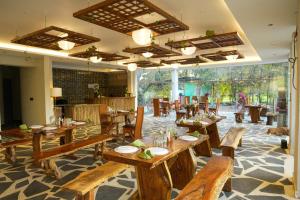 a restaurant with wooden tables and chairs and large windows at Olive in Tāla