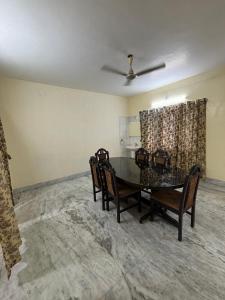 a dining room with a glass table and chairs at Trichy homestays in Tiruchirappalli