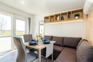 a living room with a couch and a table at NATURAMA Brombachsee Tinyhaushotel in Pleinfeld +5 photos