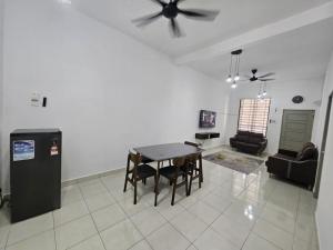 a living room with a table and chairs and a ceiling fan at Razumi's Homestay 2 in Arau +1 photo