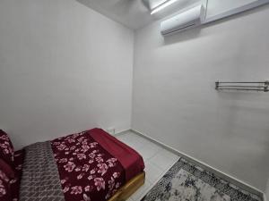 a white room with a bed with a red blanket at Razumi's Homestay 2 in Arau