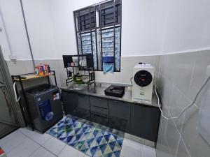 a bathroom with a counter with a hair dryer at Razumi's Homestay 2 in Arau