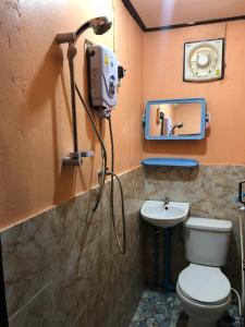 a bathroom with a toilet and a sink and a camera at Fundee Guesthouse in Pakse