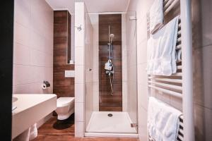a bathroom with a shower with a toilet and a sink at Hotel Pax in Luxembourg +63 photos