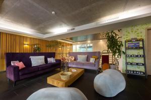 a living room with two purple couches and a table at Hotel Bonvino Badacsony in Badacsonytomaj