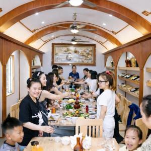 a group of people standing around a long table with food at Thành An Homestay in Hòa Bình