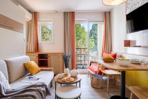 a living room with a couch and a table at Résidence Pierre & Vacances Les Citronniers in Menton