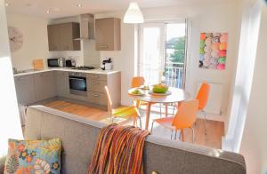 a living room with a couch and a kitchen with a table at Westlake Apartments in Peterborough