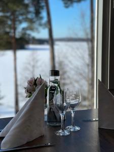 a table with two wine glasses and a bottle on it at Bommersvik Hotell & Konferens in Järna