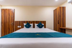 a bedroom with a large white bed with blue sheets at SAAD Residency in Cochin
