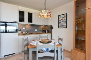 a kitchen with a table and chairs in a kitchen at Haus "Panorama" Appartement PAN024 in Duhnen