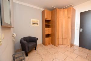 a room with a chair and a closet at Haus "Panorama" Appartement PAN024 in Duhnen +25 photos