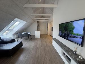 a living room with a large flat screen tv on a wall at Tollundgaard Golf Park & Apartments in Funder Kirkeby