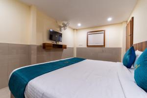a bedroom with a large white bed with blue pillows at SAAD Residency in Cochin