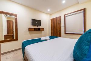 a bedroom with a bed and a tv on the wall at SAAD Residency in Cochin +17 photos