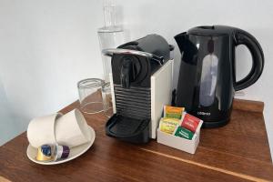 a coffee maker sitting on a wooden table with a coffee pot at BlueSky Arniston Boutique Guesthouse in Arniston