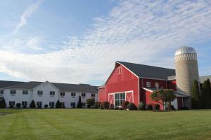 a red barn with a silo on a field at Farmstead Inn and Conference Center in Shipshewana