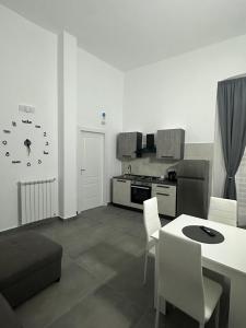 a living room with a table and a kitchen at Dimora del Corso in Caserta
