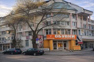 a large building with cars parked in front of it at апартамент Хармония in Gotse Delchev +3 photos