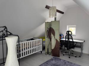 a room with a crib and a table and a desk at AlbLoft in Meßstetten