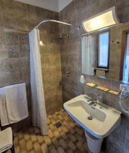 a bathroom with a sink and a shower with a mirror at Hotel Ristorante Daino in Pietramurata +21 photos