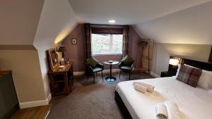 a bedroom with a bed and a table and chairs at Springburn Farmhouse in Spean Bridge +48 photos