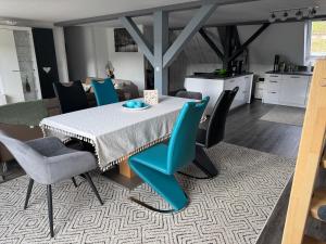 a dining room with a table and blue chairs at AlbLoft in Meßstetten +20 photos
