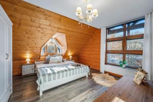 a bedroom with a bed in a room with wooden walls at ZRUB BINDT in Hnilčík