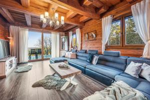 a living room with a blue couch and a table at ZRUB BINDT in Hnilčík